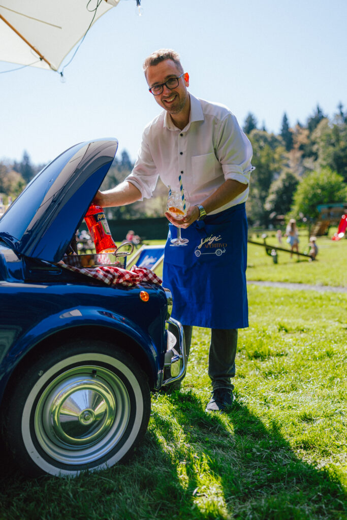 Boštjan Mišič, ustanovitelj Luigi Aperitiva, ob svojem modrem Fiatu 500 – gostinec, ljubitelj Italije in ustvarjalec mobilnega bara z dušo.